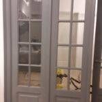 Reconditionare usi Bucuresti 3 Uși interioare gri cu geamuri din sticlă, având un design cu panouri multiple.