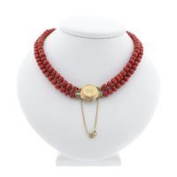 Antique blood coral bead necklace with gold clasp.