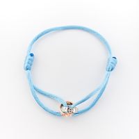 Bracelet made of light blue satin cord with two-tone gold rings; Løve