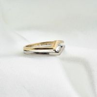 Two-tone gold solitaire ring with 0.17 ct diamond.