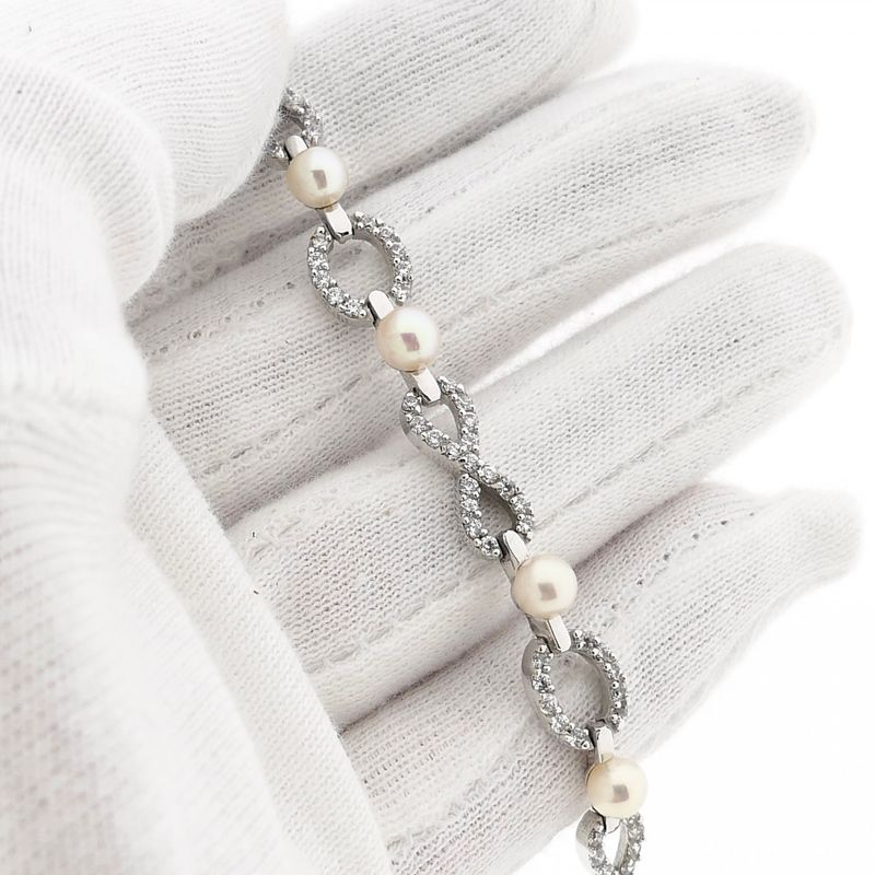 Afbeelding 6 van Witgouden infinityschakel armband met parel en zirconia | 19,5 cm