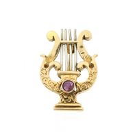 Gold brooch of a lyre harp with ruby