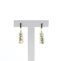 Gold earrings with meander pendant.