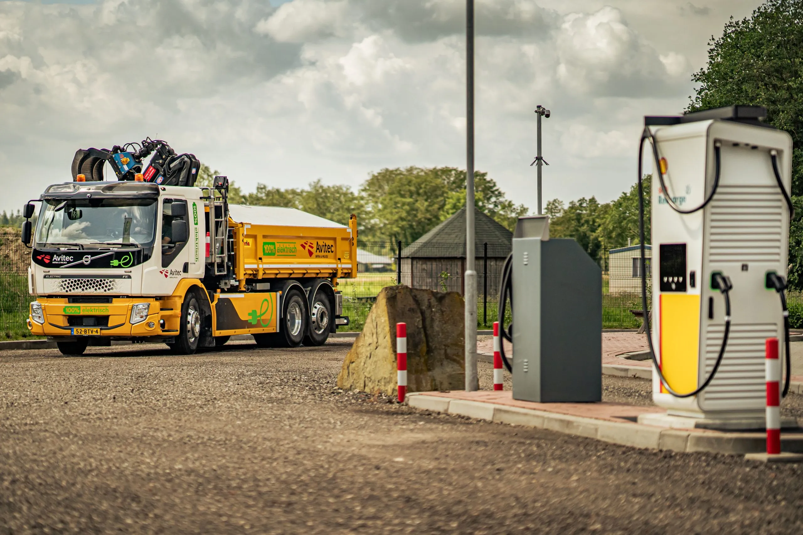 Elektrische vrachtwagen laadt op bij laadplein voor duurzaam vrachtverkeer